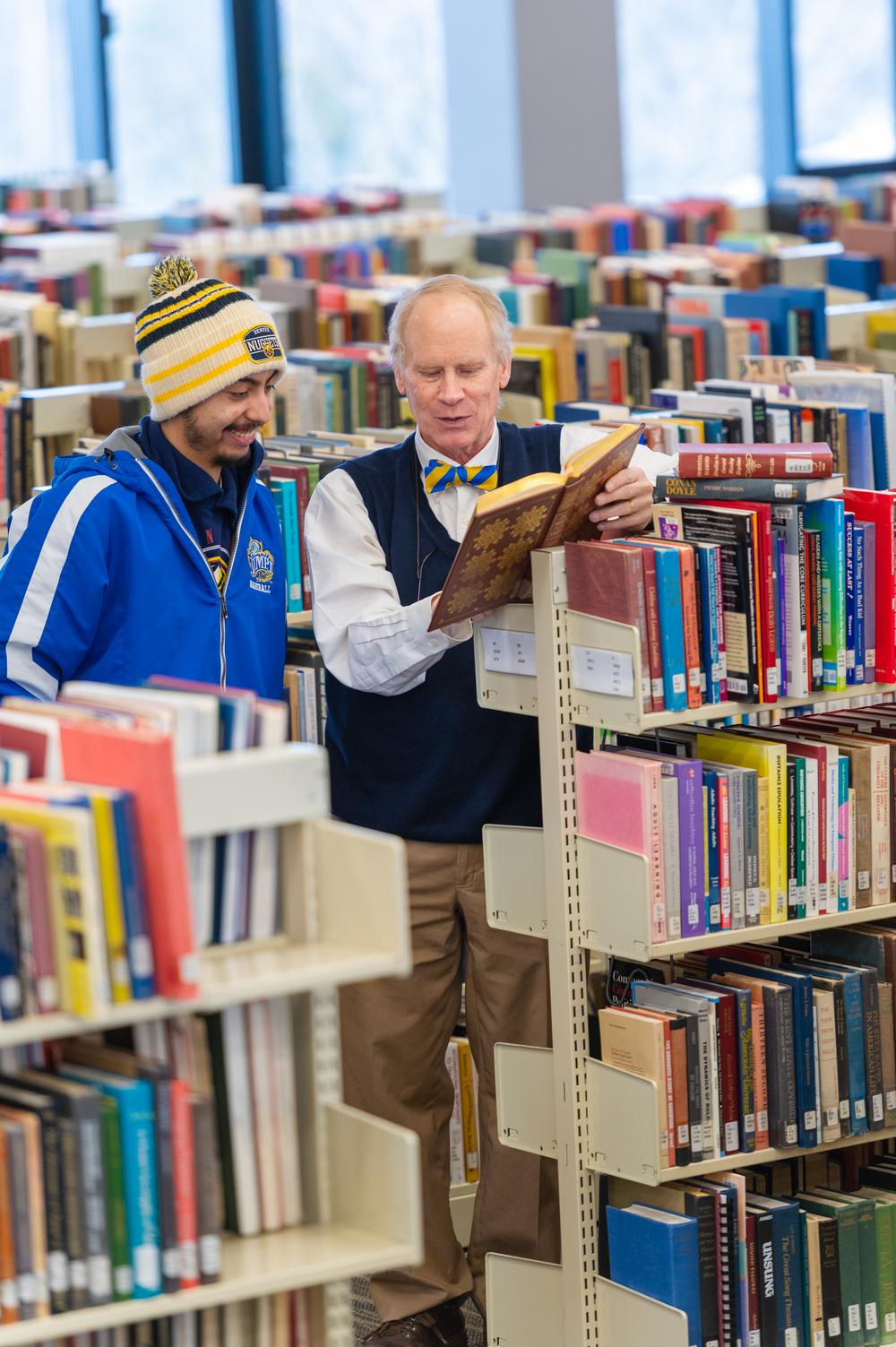 photo of librarian with student by bookshelf